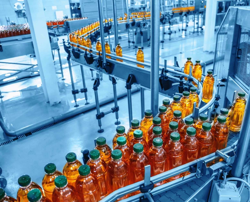 Conveyor belt, juice in bottles on beverage plant or factory interior in blue color, industrial production line
