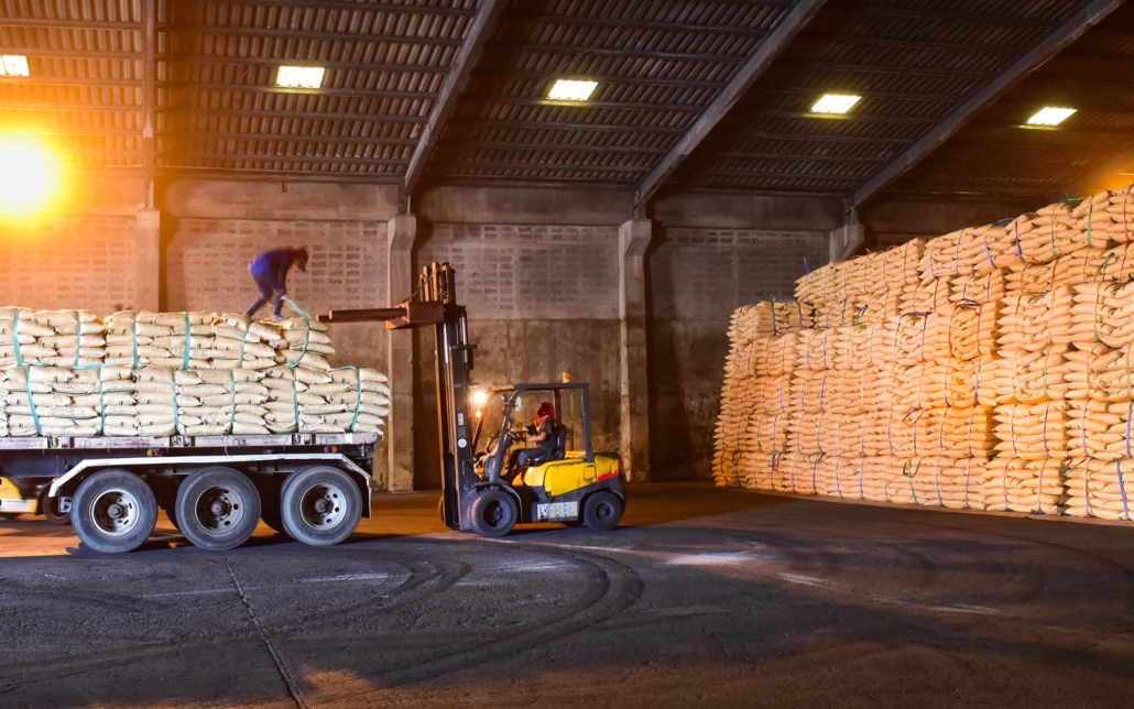 Warehouse intake, forklift lift-off sugar bags from truck to stack inside a warehouse_