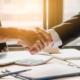 Image of two business people shaking hands on a loan.