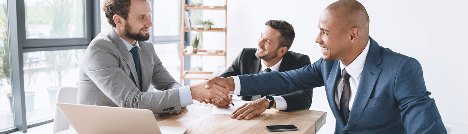 Side view of multiple businessmen shaking hands in deal